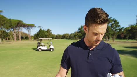 Glücklicher-Golfspieler,-Der-Den-Golfball-Untersucht
