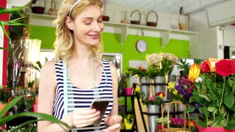Female-florist-using-mobile-phone-in-flower-shop