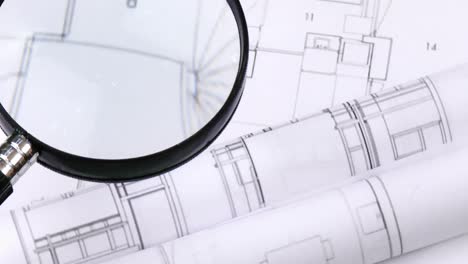 High-view-of-magnifying-glass-over-architecture-plans