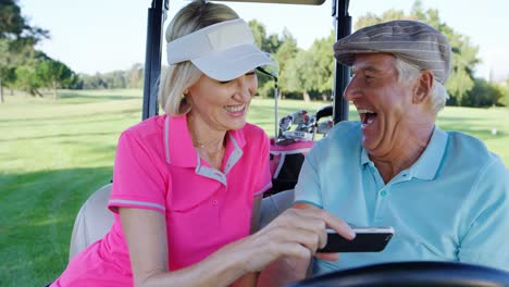 Two-golfers-taking-a-selfie-in-golf-buggy
