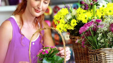 Female-florist-arraigning-flower-in-wicker-basket
