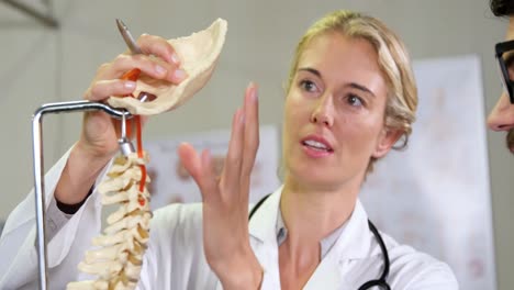 Physiotherapist-explaining-spine-model-to-patient