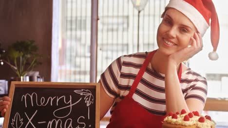 Waitress-holding-chalkboard-with-x-mas-message
