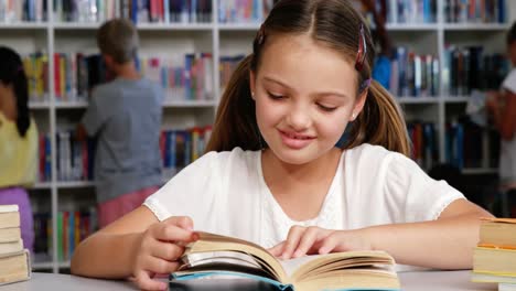 Schoolgirl-reading-book-in-library