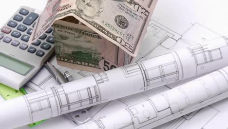 Dollar-house,-blueprints-and-calculator-turning