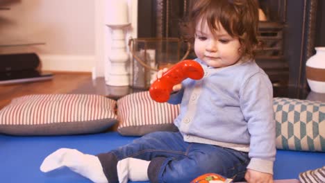 Cute-baby-girl-playing-with-toy-telephone
