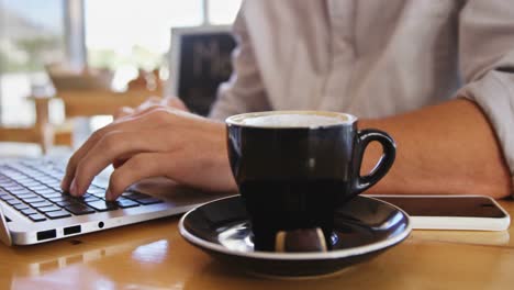 Mann-Benutzt-Laptop,-Während-Er-Eine-Tasse-Kaffee-Trinkt
