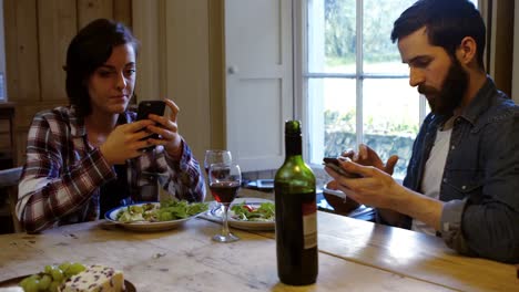 Paar-Benutzt-Mobiltelefon-Beim-Essen