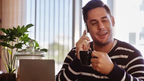 Man-talking-on-mobile-phone-while-having-coffee