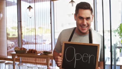 Smiling-waiter-with-chalkboard