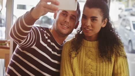 Young-couple-taking-selfie-in-cafeteria