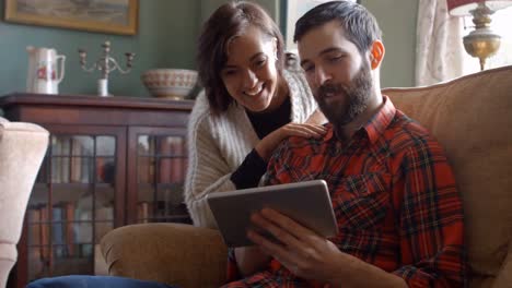 Couple-using-digital-tablet-in-living-room