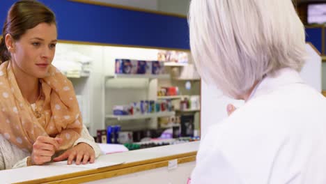 Pharmacist-assisting-the-bottle-of-drug-to-customer