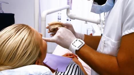 Zahnarzt-Zeigt-Einer-Patientin-Modellzähne