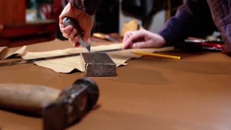 Shoemaker-cutting-a-piece-of-leather