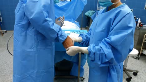 Krankenschwester-Hilft-Einem-Chirurgen-Beim-Tragen-Von-OP-Handschuhen