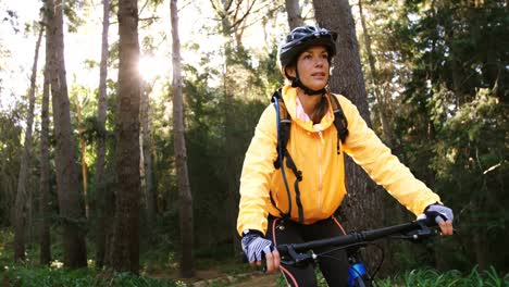 Female-mountain-biker-riding-in-the-forest