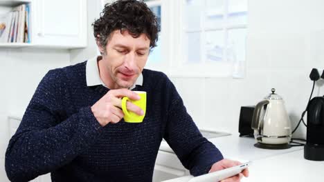 Man-using-digital-tablet-while-having-coffee
