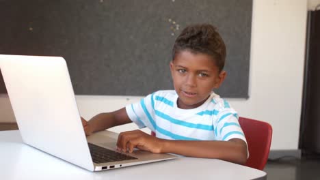 Schoolboy-using-laptop-in-classroom