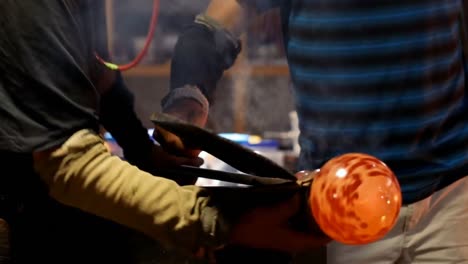 Team-of-glassblowers-shaping-a-molten-glass