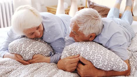 Senior-couple-interacting-while-relaxing-on-bed