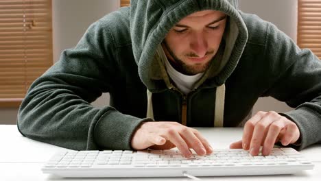 Man-wearing-a-hooded-and-working-on-computer