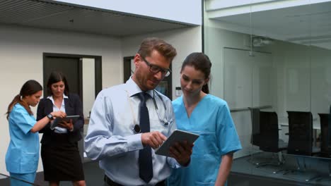 Médicos-Discutiendo-Sobre-Tableta-Digital-Con-Enfermera
