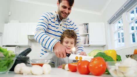 Father-teaching-his-son-to-chop-vegetables