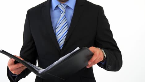 Mid-section-of-businessman-holding-file-folder-and-checking-time
