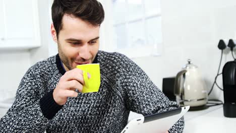 Man-using-digital-tablet-while-having-coffee