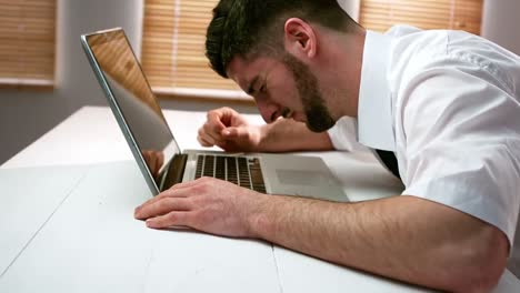 Tired-businessman-sleeping-on-laptop-at-desk