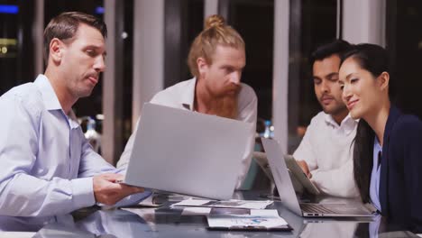 Business-people-discussing-over-laptop