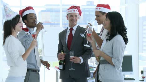 Business-people-celebrating-Christmas-in-office-while-drinking-champgane
