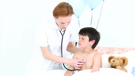 Doctor-listening-with-a-stethoscope-to-a-boy-in-hospital