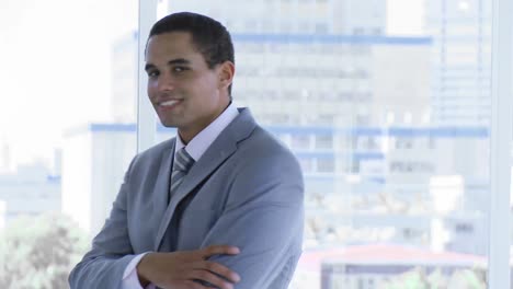 Businessman-standing-in-office-smiling-at-the-camera