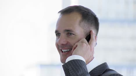 Businessman-talking-on-mobile-phone-in-office