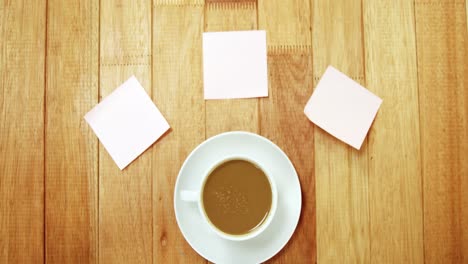 Close-up-of-coffee-cup-with-saucer-and-sticky-note