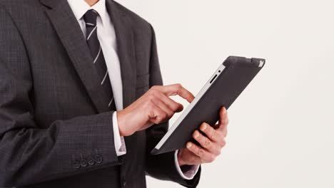 Mid-section-of-businessman-using-digital-tablet