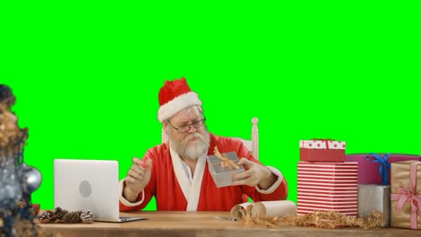 Weihnachtsmann-Benutzt-Laptop,-Während-Er-Die-Geschenkbox-überprüft