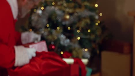 Weihnachtsmann-Mit-Finger-Auf-Den-Lippen,-Der-Geschenkschachteln-In-Eine-Weihnachtstüte-Steckt