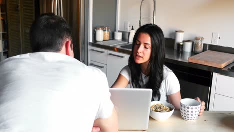Couple-using-laptop-while-having-breakfast