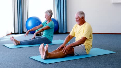 Senior-citizens-performing-stretching-exercise