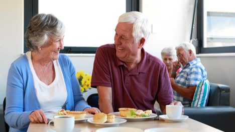 Senior-couple-interacting-with-each-other-while-having-breakfast