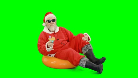 Weihnachtsmann-Sitzt-Auf-Aufblasbarem-Schlauch-Und-Trinkt-Cocktail