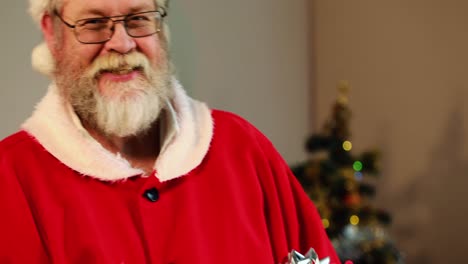 Santa-claus-checking-a-gift-box-and-smiling