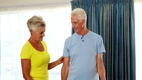 Trainer-assisting-senior-citizens-in-performing-exercise