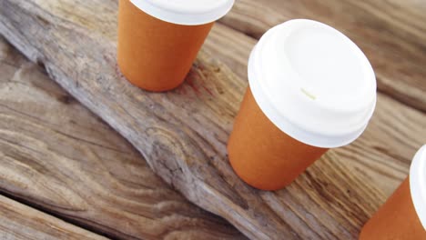 Disposable-cup-in-a-row-on-wooden-plank