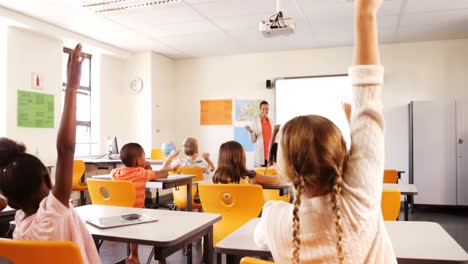 School-kids-raising-hand-in-classroom