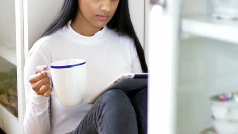 Beautiful-woman-using-digital-tablet-while-having-cup-of-coffee