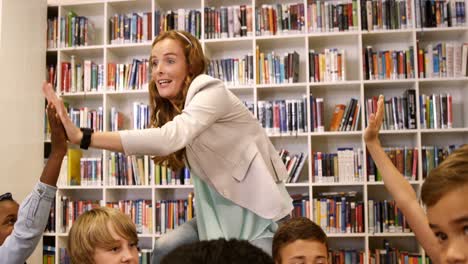 Teacher-giving-high-five-to-kids-in-library